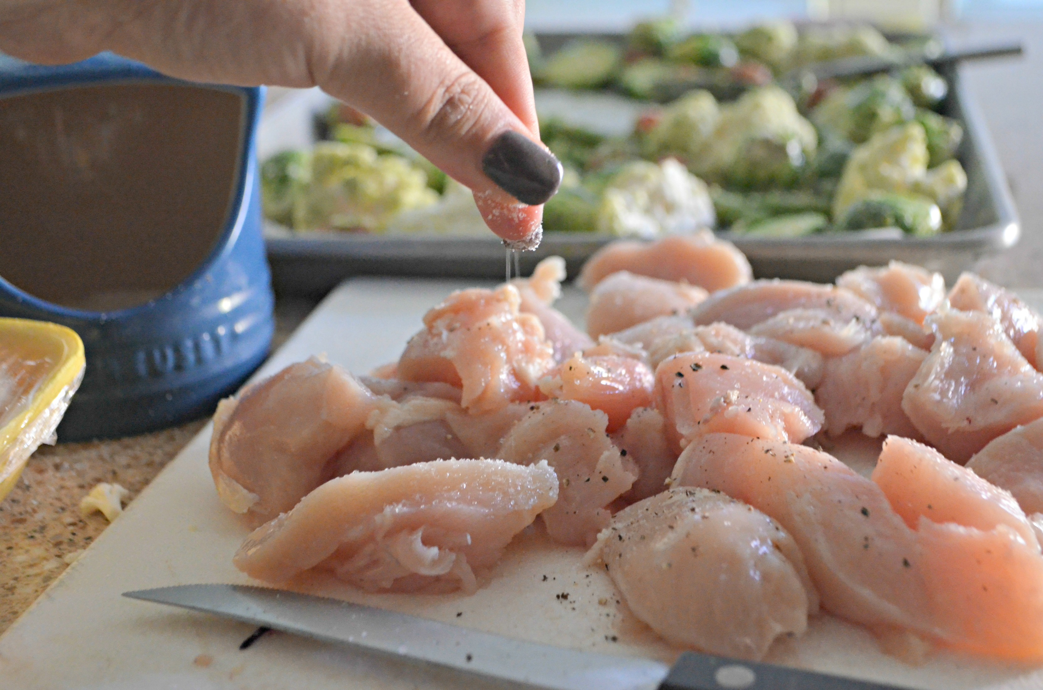 pinching salt over uncooked chicken