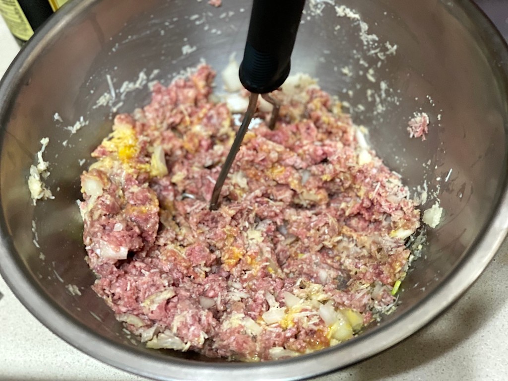 mashing ground beef in bowl