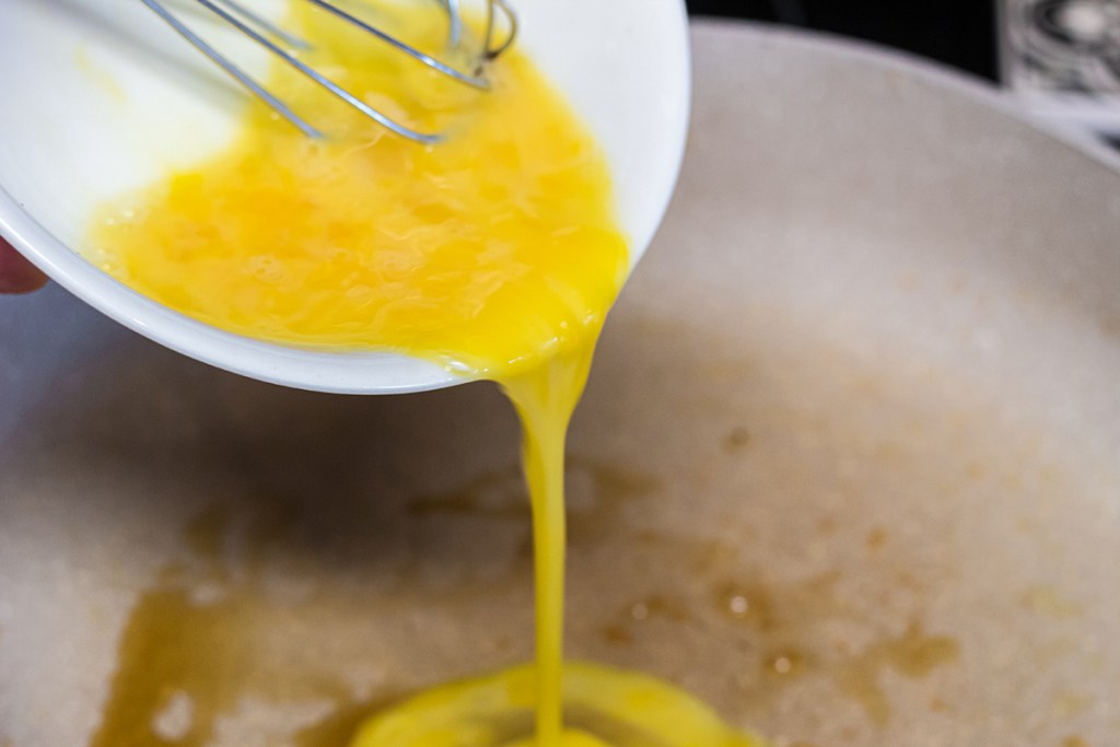 pouring eggs into skillet