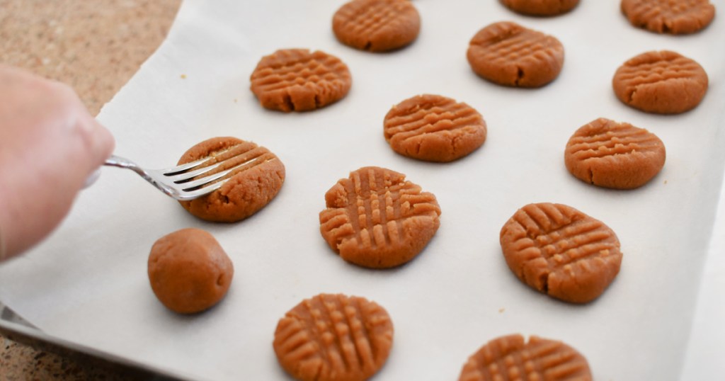spreading keto peanut butter cookies with a fork