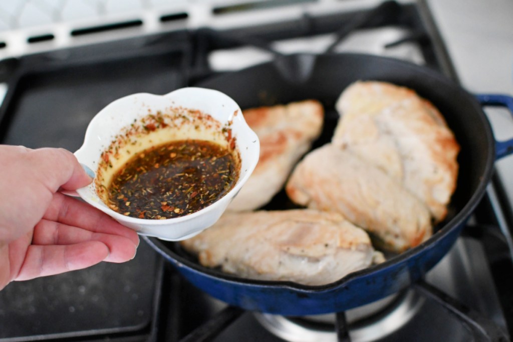 pouring lemon butter on chicken