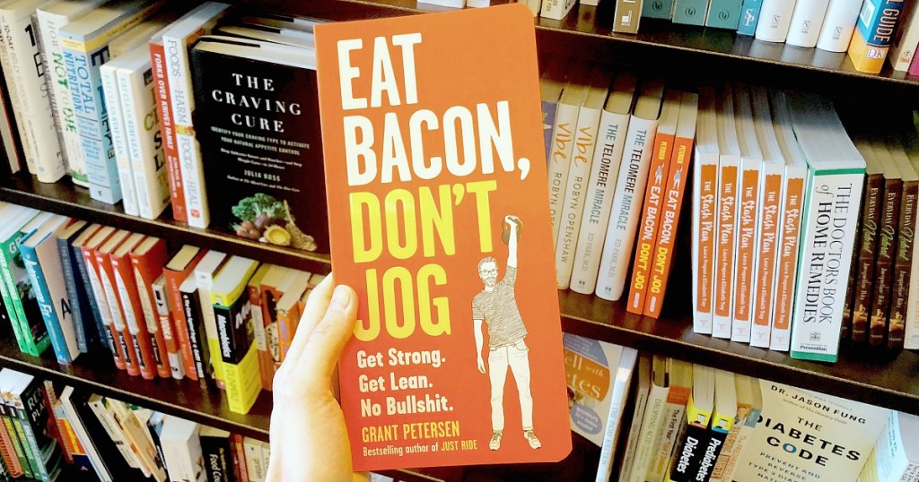 holding Eat Bacon, Don't Jog book at bookstore 