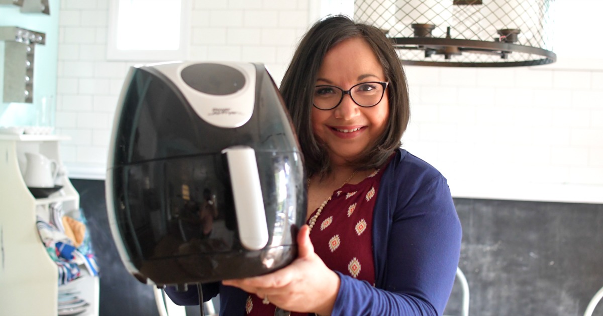 woman holding an air fryer in the kitchen