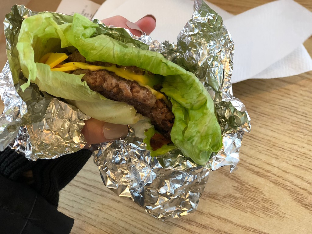 holding lettuce-wrapped burger 