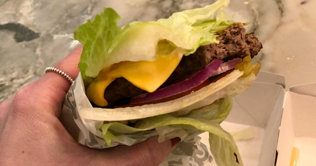 holding keto lettuce-wrapped burger from Carl's Jr.