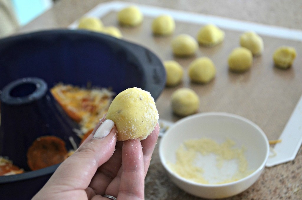 holding keto dough ball rolled in parmesan cheese 