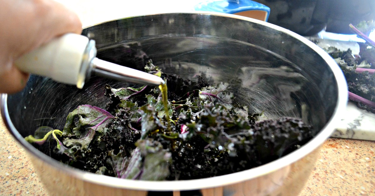 keto air fryer kale chips - drizzling oil over the kale
