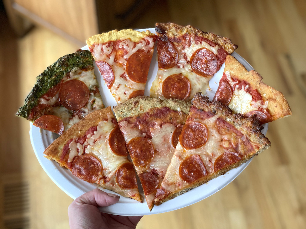 holding plate of keto pizza crusts