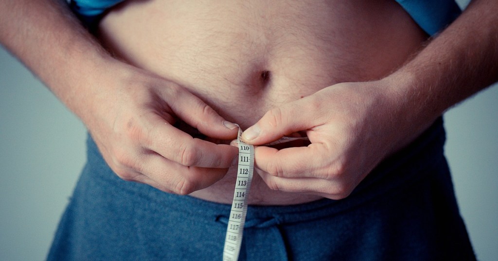 man measuring stomach