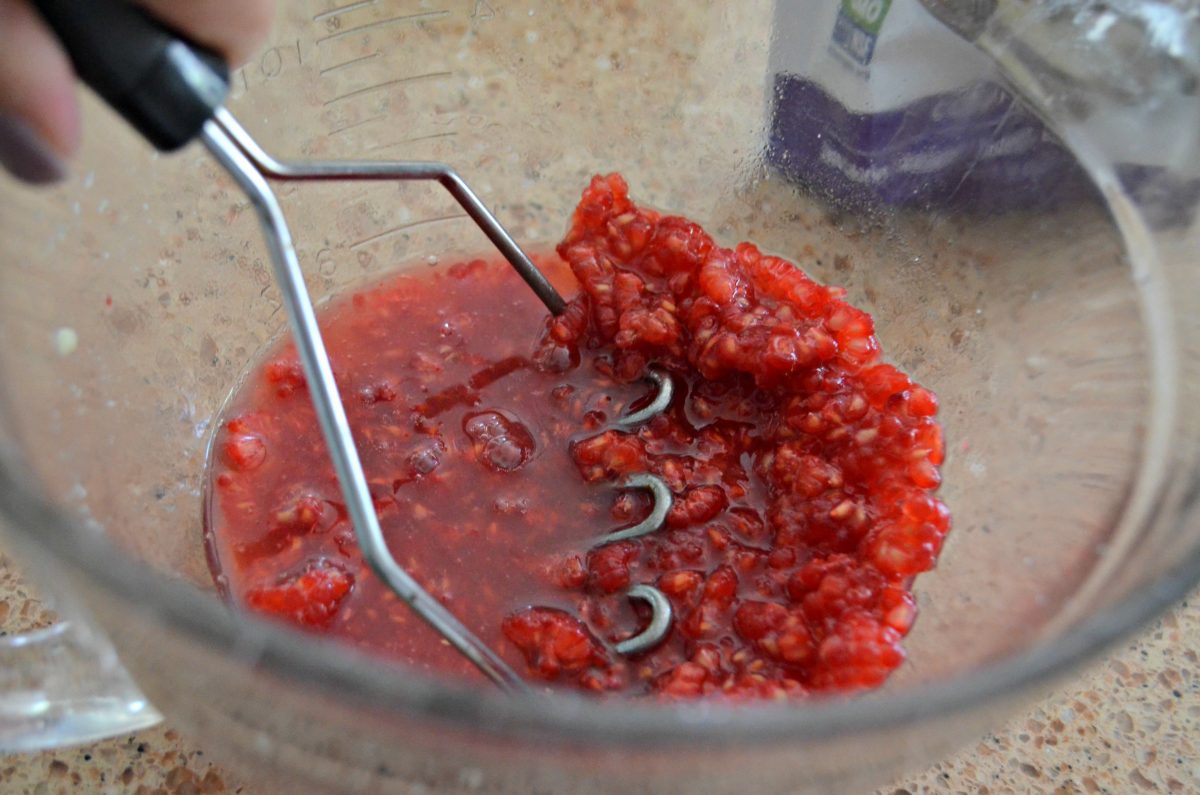 mashing raspberries for keto pie fillng 