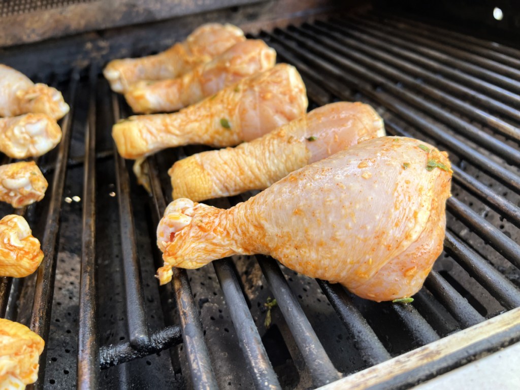 adding chicken to a bbq grill