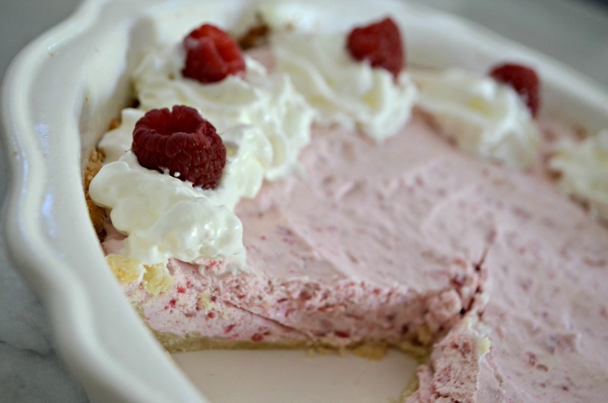 keto raspberry cream pie – Closeup of the pie in the pan with a slice missing
