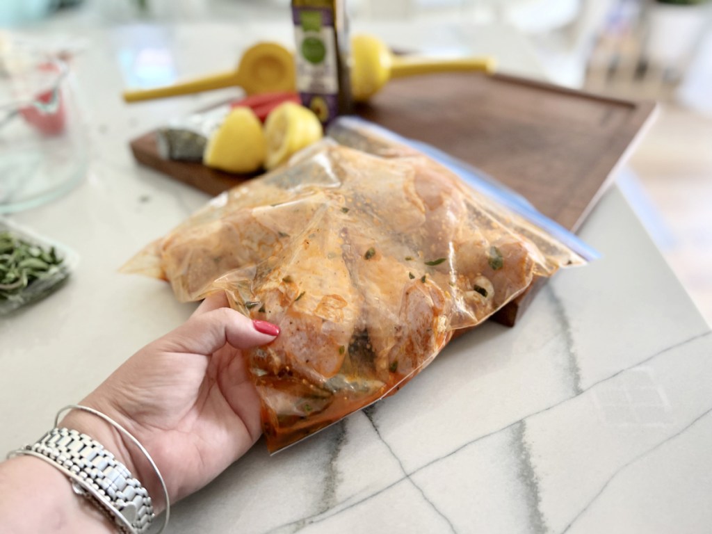 mixing drumsticks with marinade in a plastic ziploc