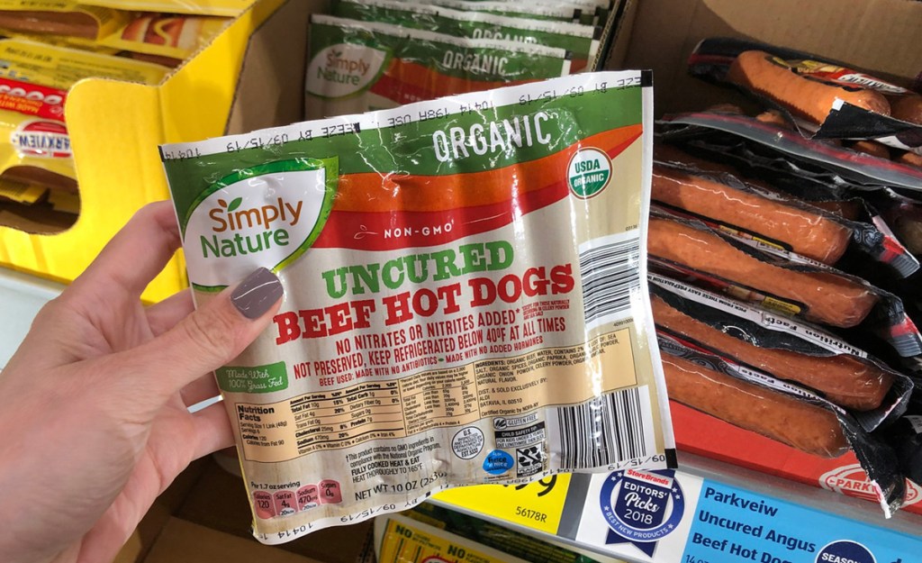 hand holding pack of organic beef hot dogs