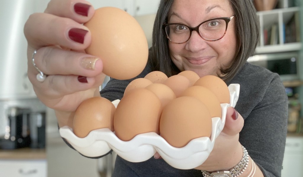 person holding a dozen eggs