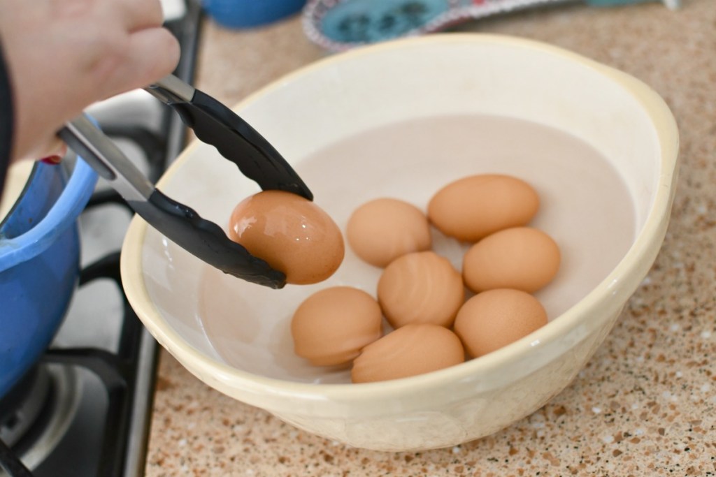 placing hard-boiled eggs in cool water