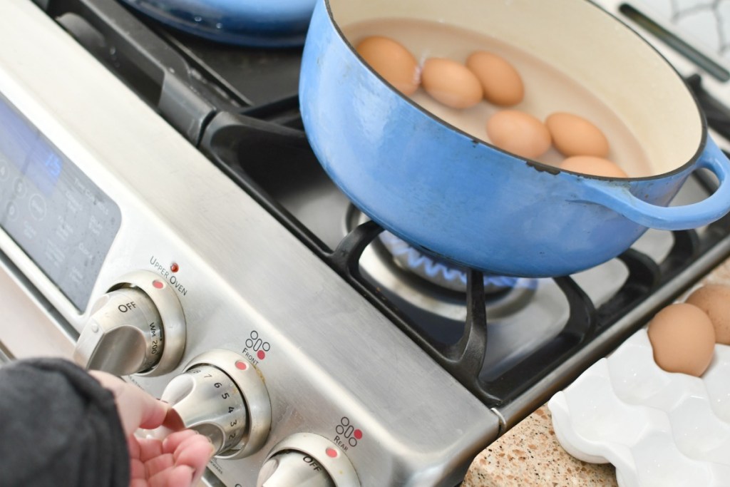 turning on a stove to cook eggs