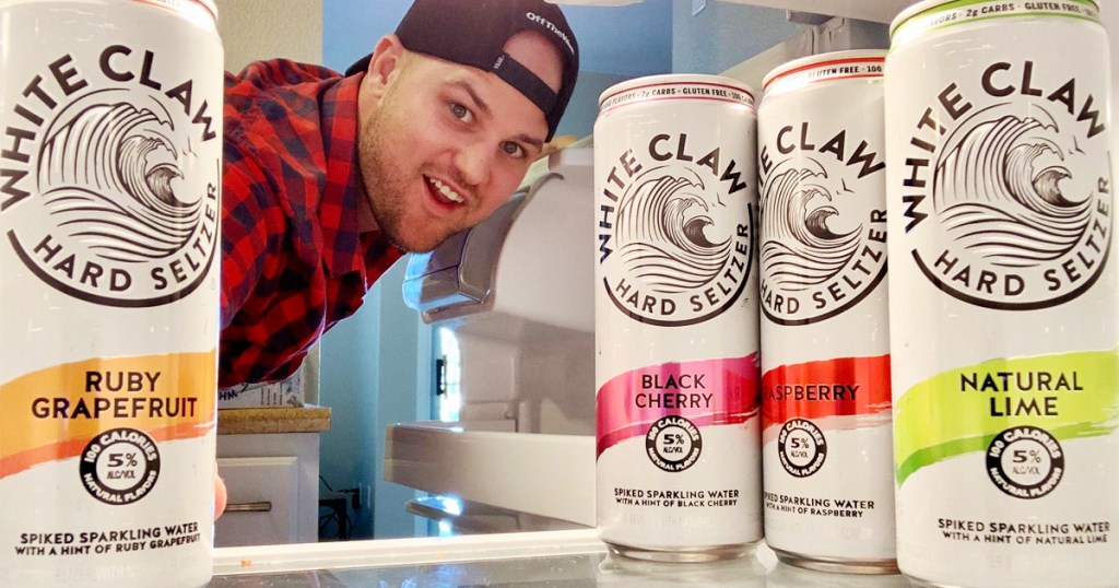 man looking at white claw seltzer in refrigerator