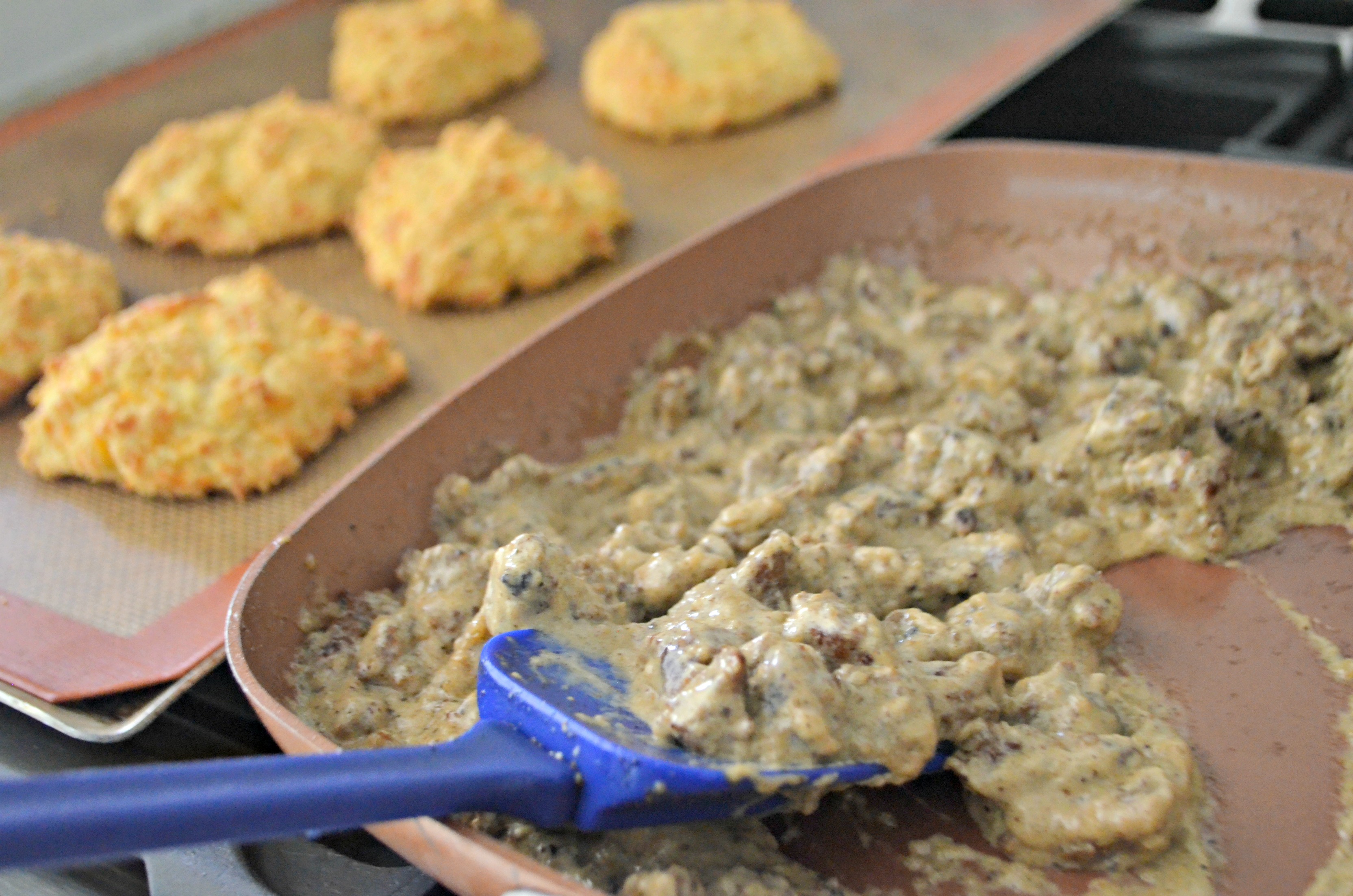 Keto Biscuits and Gravy - gravy in the pan with biscuits nearby