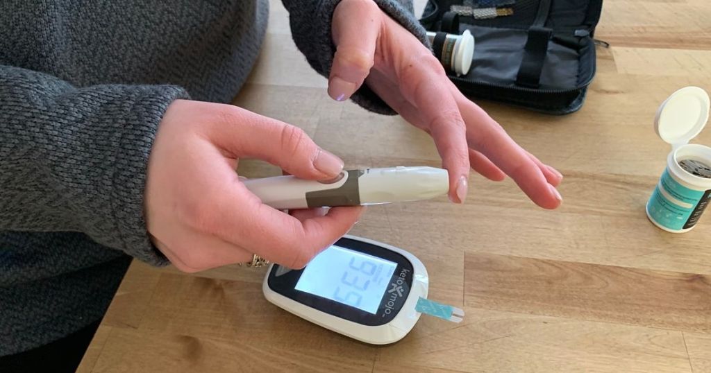 A woman using a blood ketone meter