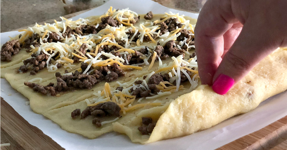 Easy Keto Taco Stuffed Breadsticks – folding up the dough around the meat