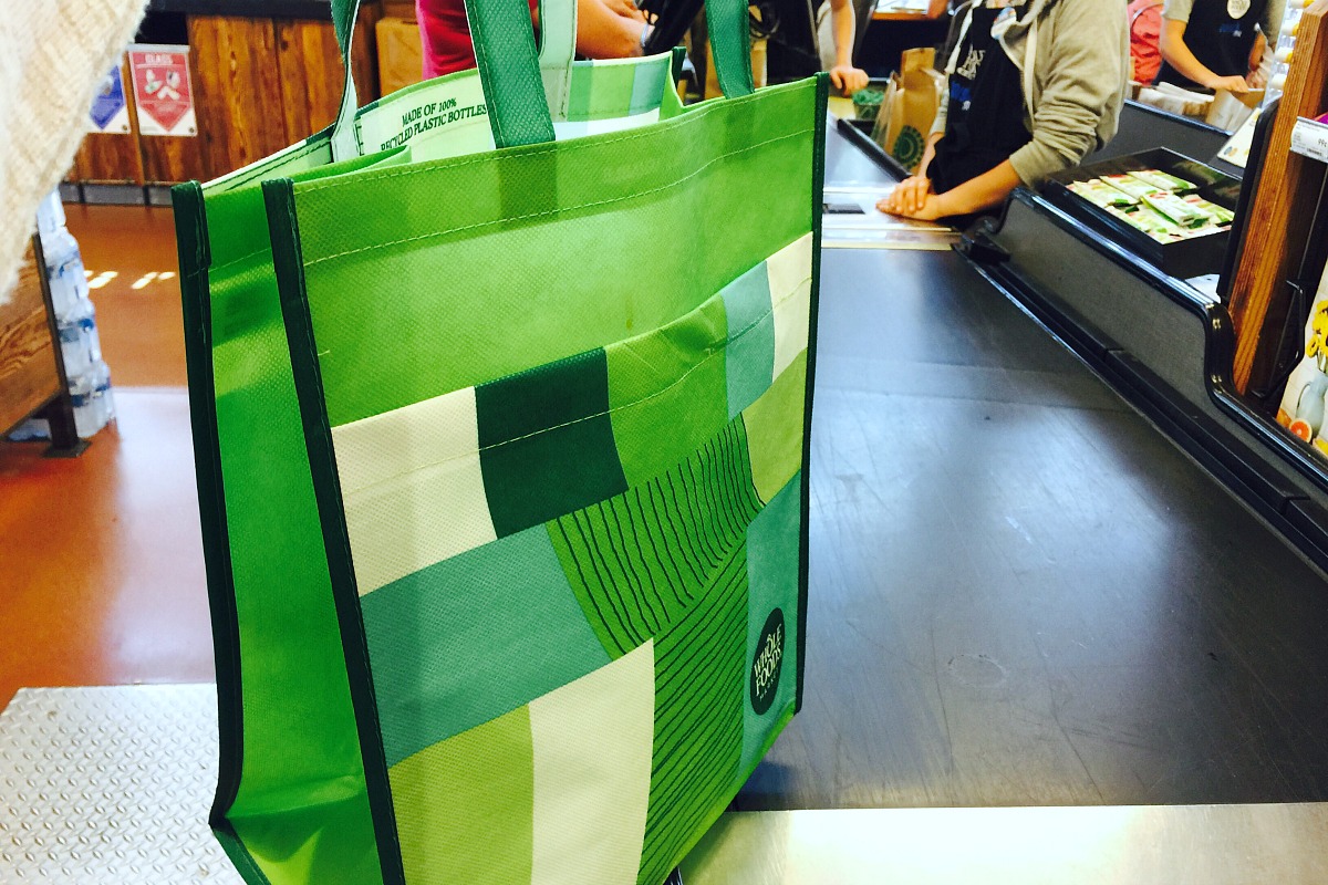 keto whole foods shopping tips to save money — reusable grocery shopping bag in checkout line at whole foods