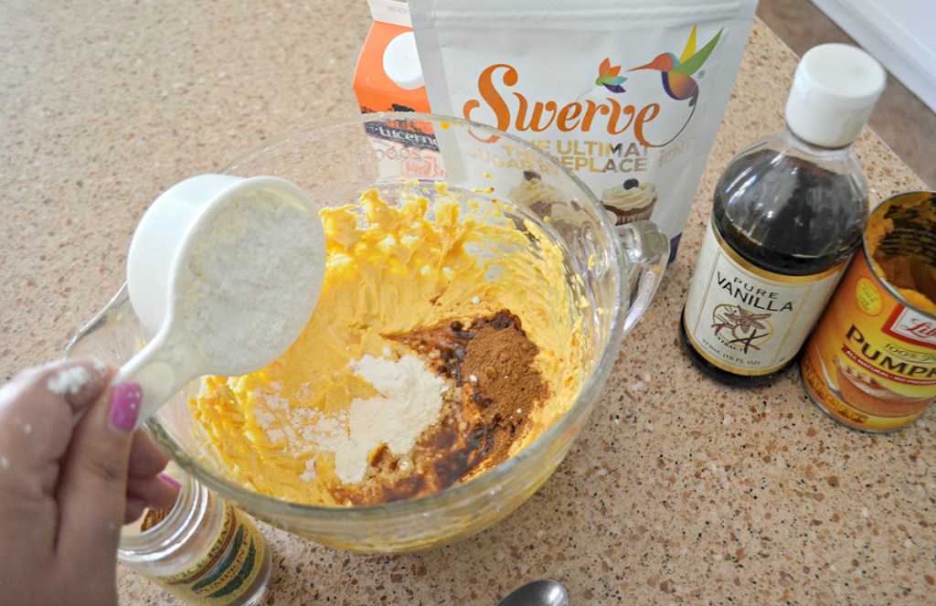 adding Swerve sweetener to bowl of keto pumpkin cheesecake mousse