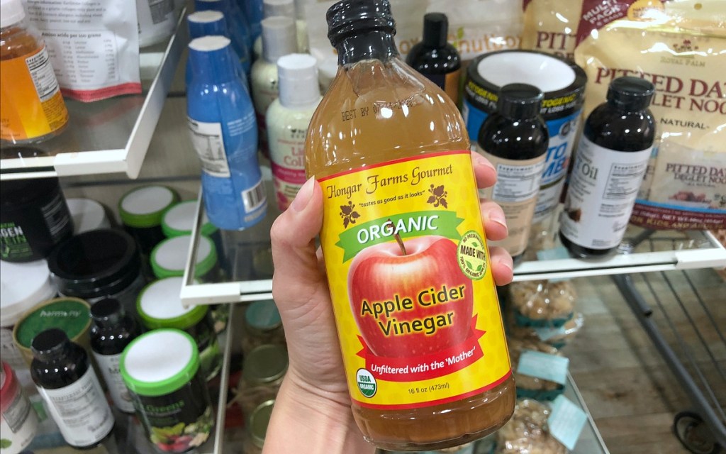 holding bottle of organic apple cider vinegar