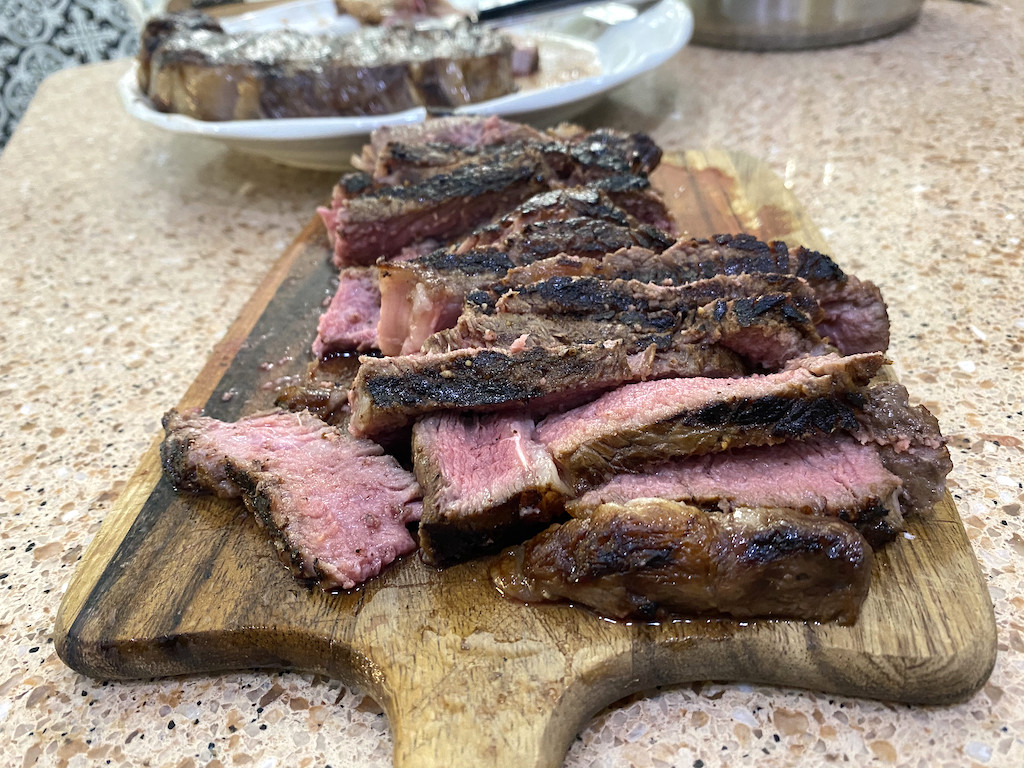 steak sliced up on cutting board 