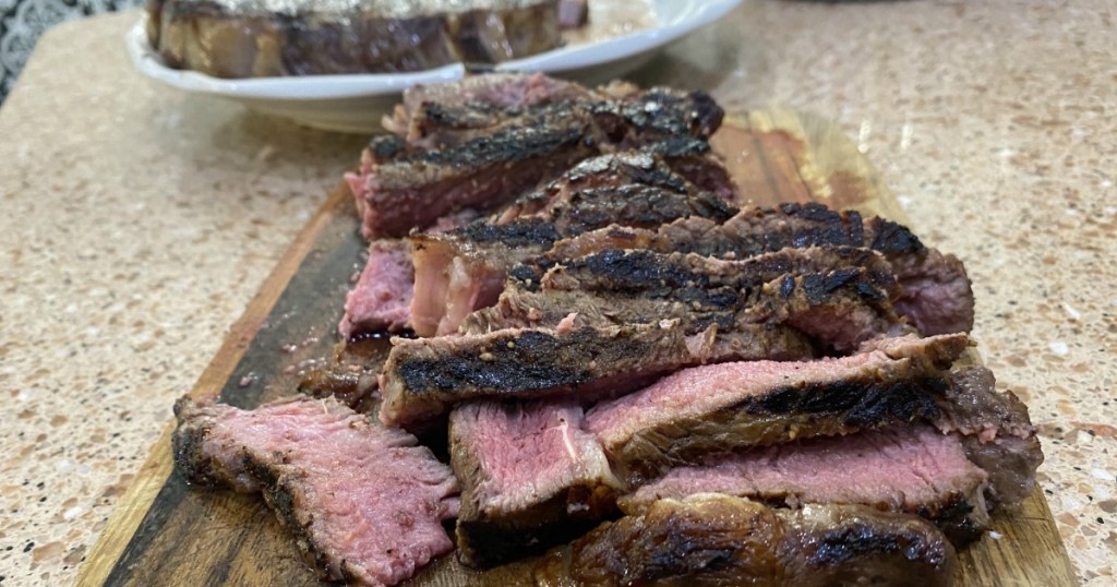 sliced steak on cutting board 