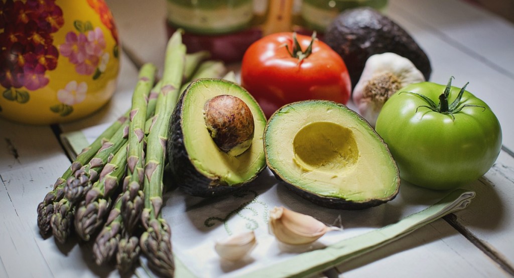 keto vegan diet — assortment of vegetables like asparagus, tomatoes, and avocados