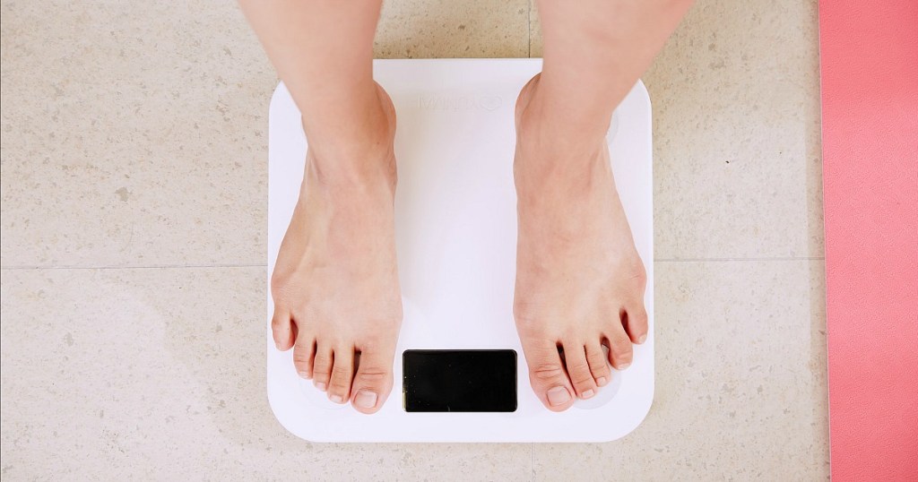 common keto mistakes — woman standing on scale waiting for weight