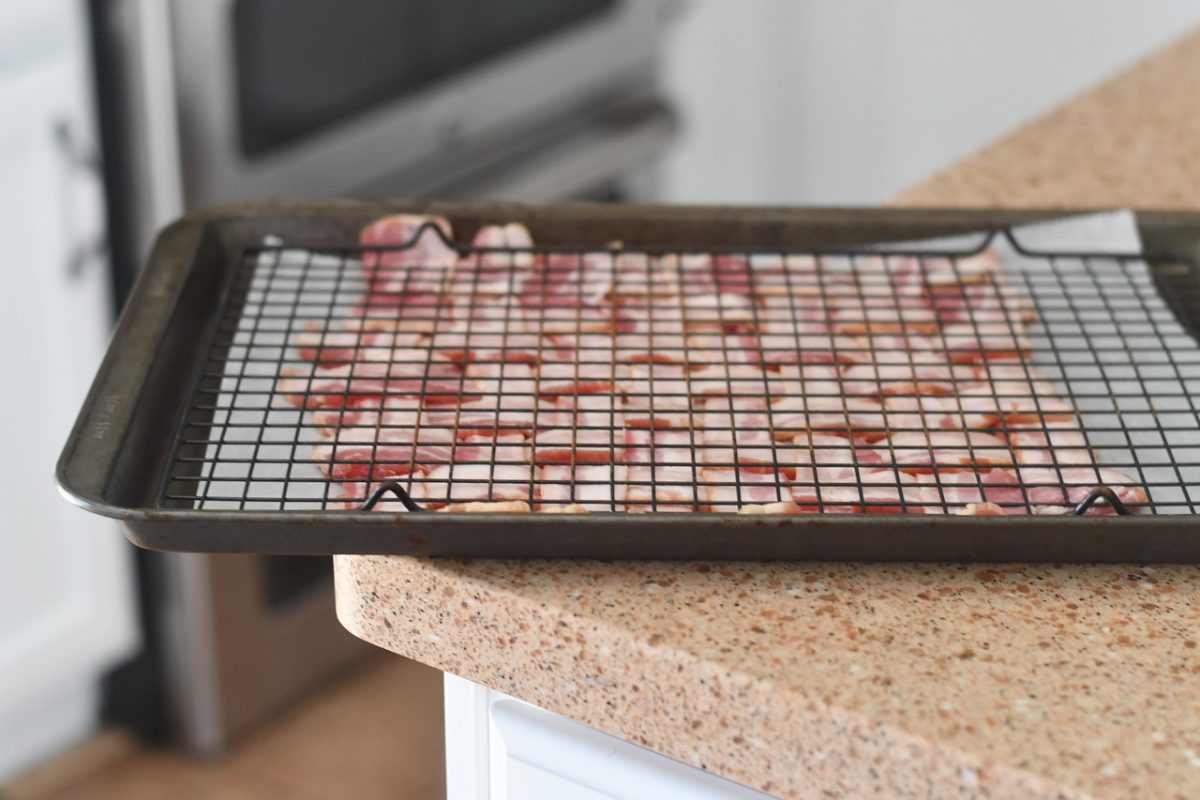 Keto BBQ Chicken Bacon Weave Pizza – pressing the uncooked bacon flat with a cooling rack