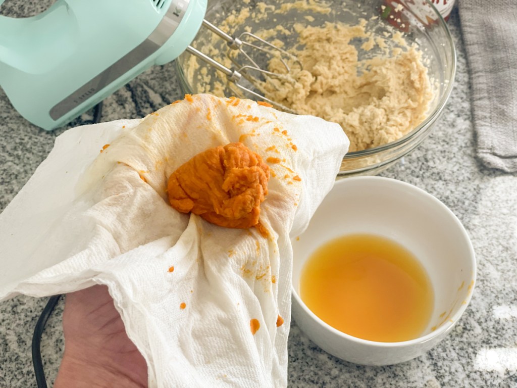 holding strained pumpkin puree in a papertowel