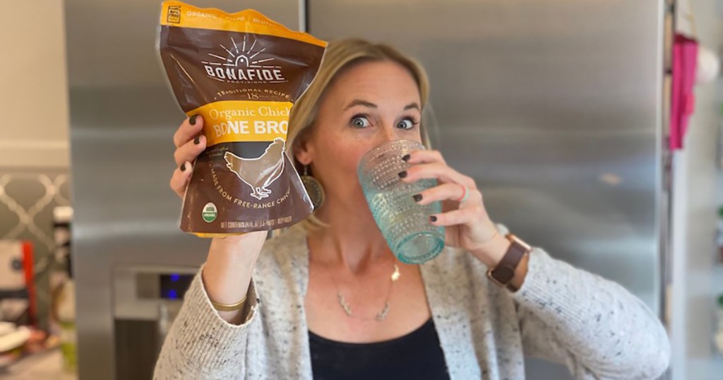 woman holding bone broth and glass of water