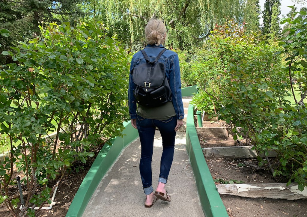 woman walking outside wearing backpack