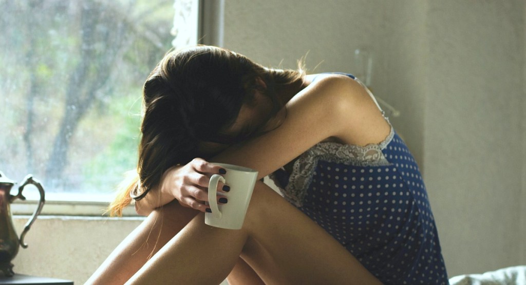 woman with head down from headache