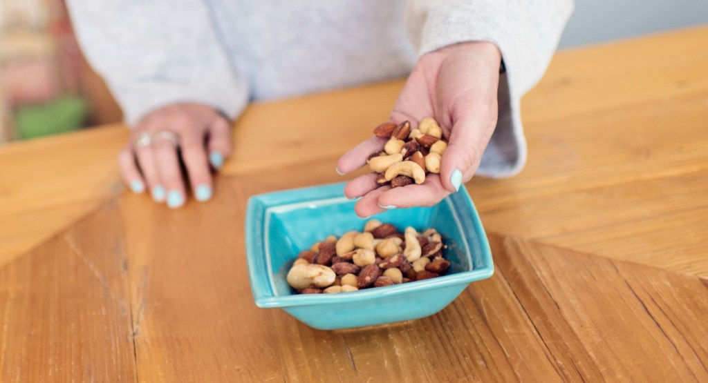 tips and tricks for fasting - mixed nuts in hand for snacking before first meal
