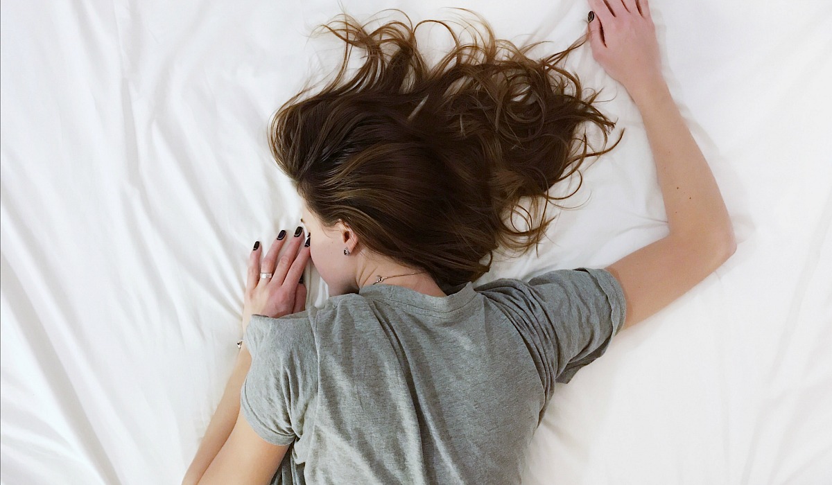 woman asleep on bed discomfort