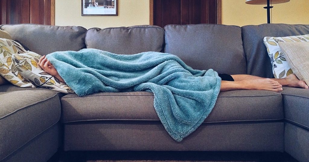 fatigued, tired person sleeping on couch