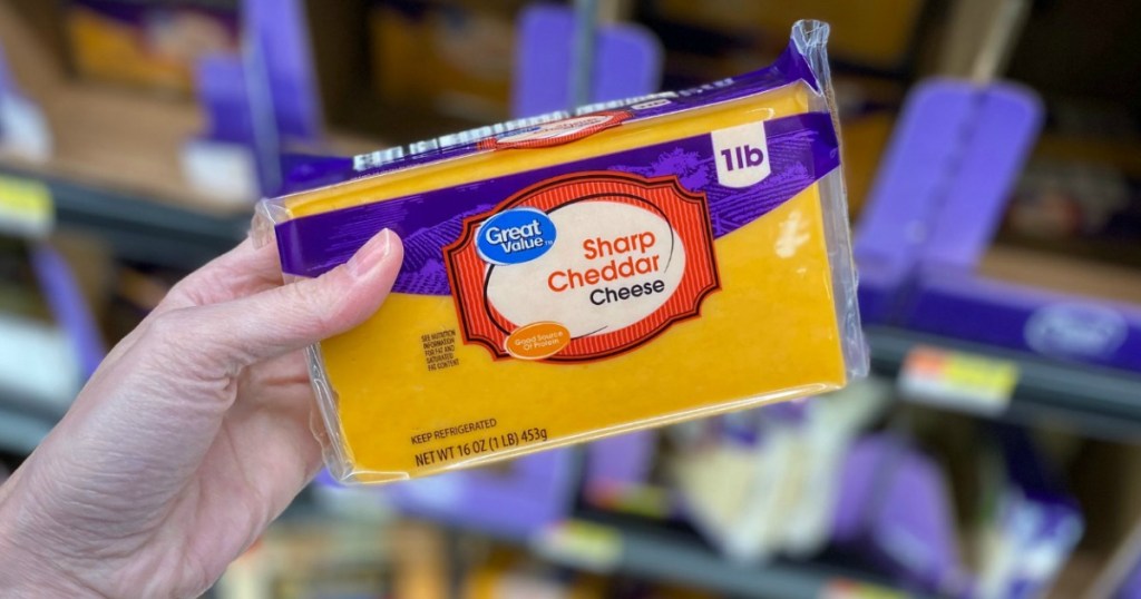 holding Sharp cheddar cheese block at Walmart
