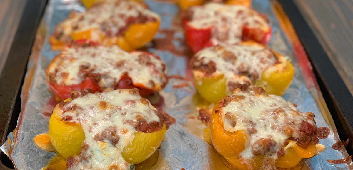 low-carb stuffed lasagna bell pepper boats – eight pepper boats on a pan fresh from the oven