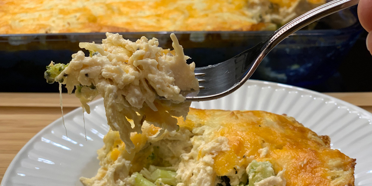 keto chicken cheese broccoli casserole - a fork with a big cheesy bite