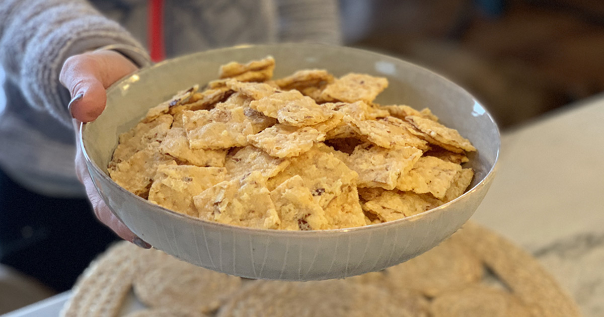 Crispy Keto Parmesan Almond Crackers - person serving a bowl full