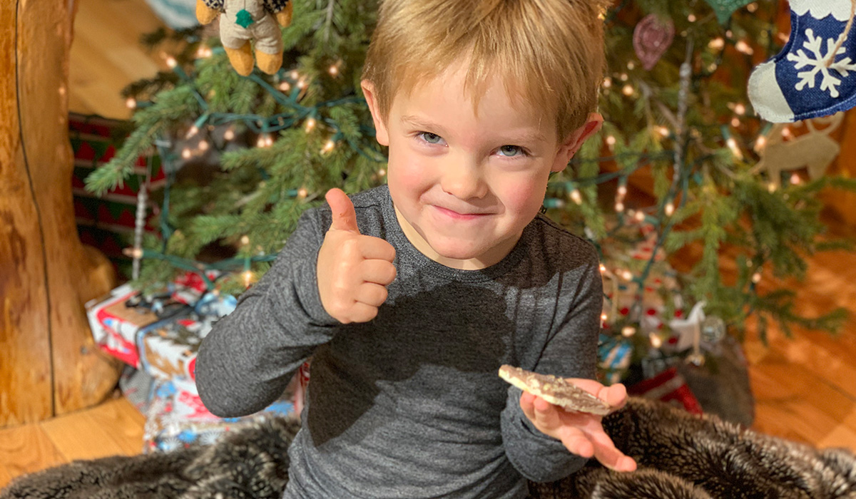 A young boy giving the thumbs up and smiling