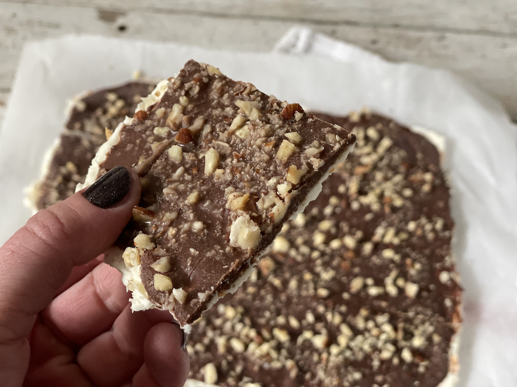 holding piece of almond joy keto bark