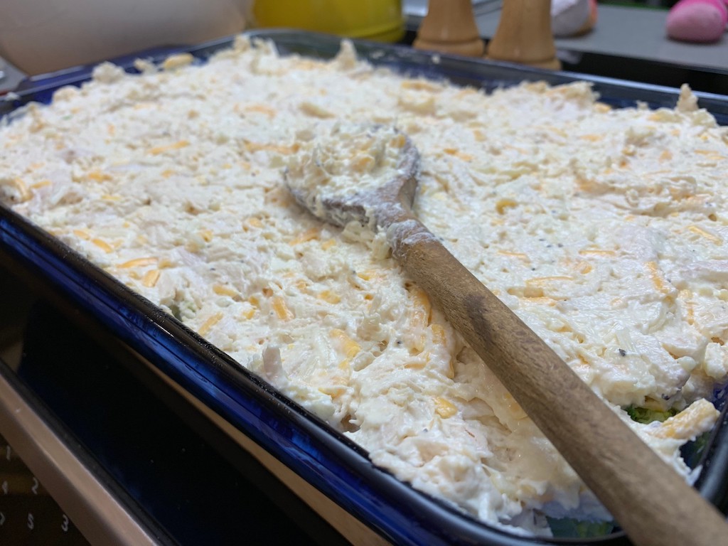 spreading cheese and shredded chicken mixture in casserole dish