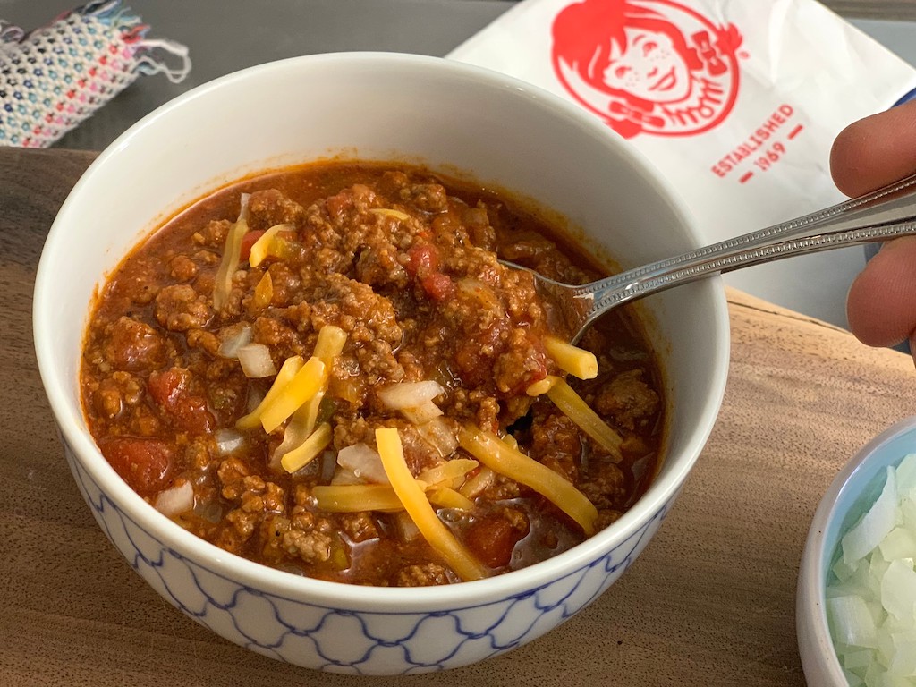 close up of Wendy's chili recipe in a bowl with shredded cheese 