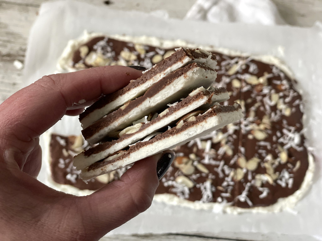 holding large stack of keto chocolate bark