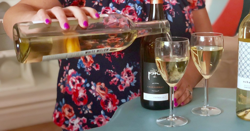 woman pouring white wine into wine glass